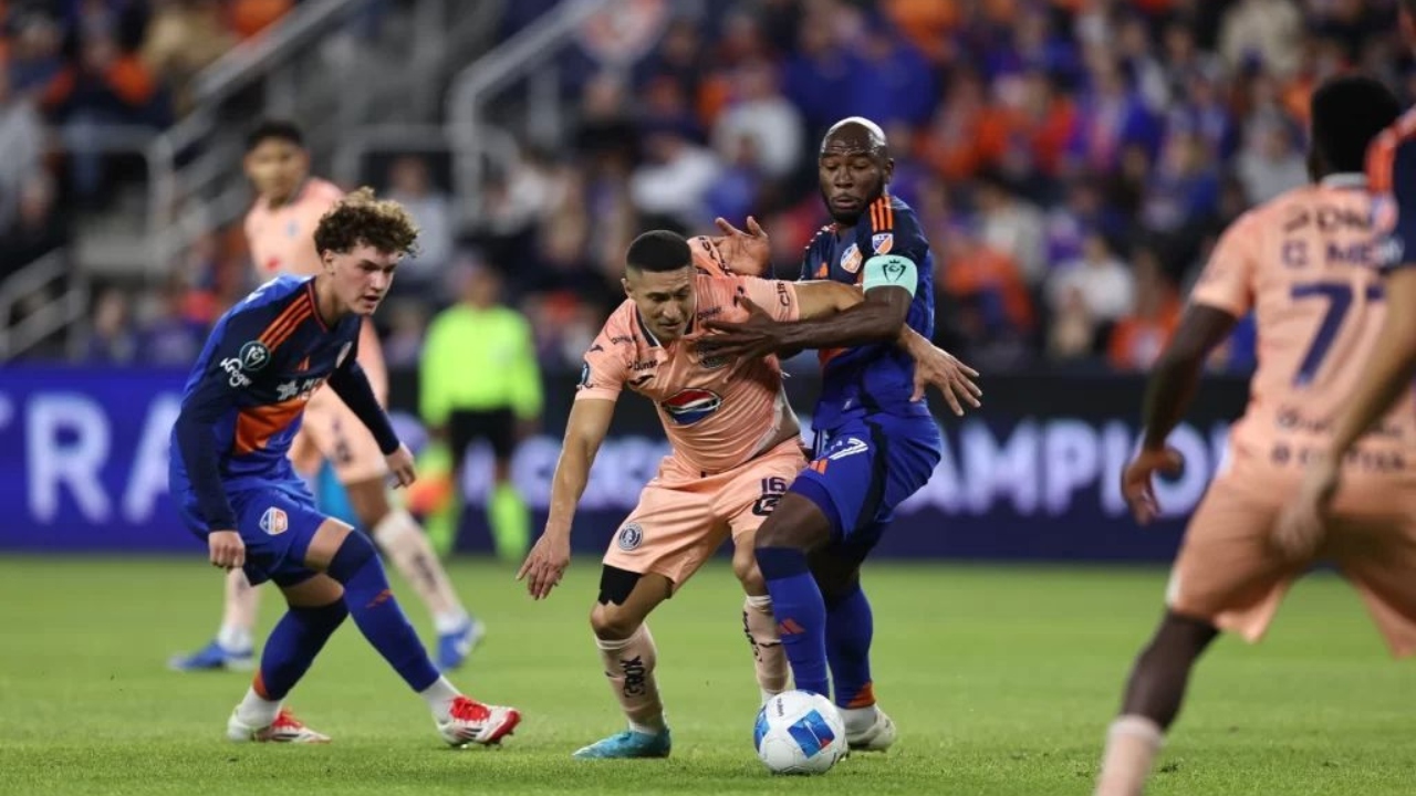 El jugador del Motagua, Héctor Castellanos con el balón entre varios jugadores del Cincinnati.
